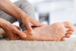 Man hands giving foot massage to yourself after a long walk